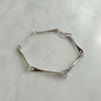 Silver bracelet on a light gray background
