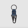 A keychain with a black metal carabiner and key ring, featuring a textured navy blue leather strap shown on a light gray background.