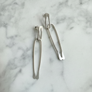 Silver earrings on a marble surface