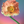 A single large poppy flower with ruffled peach-pink petals, a yellow-orange center, and a green stem against a soft gradient background shifting from blue to pink.